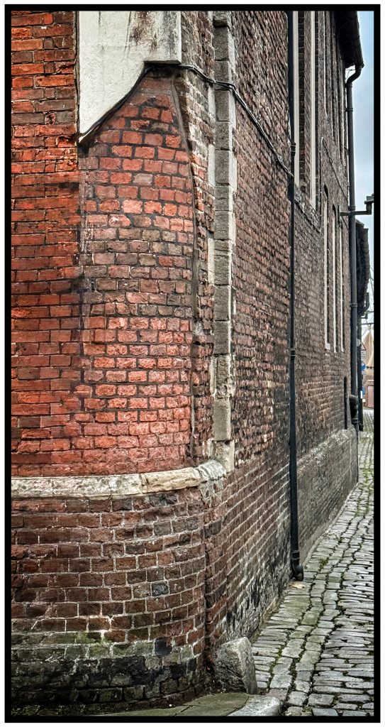 Corner of Queen Street and King's Staithe Lane, King's Lynn, showing the rounded corner tor facilitate the turning of carts that was required by the Paving Act 
Photo © J.Rye 2025
