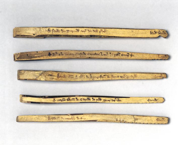 Five of Sixteen exchequer tallies (stocks only). Exchequer tally sticks c.1440. Each stick contains notches to show the amount deposited, the name of the lender, the county, the time of year when the money can be repaid, and the year. The exchequer held the other half of the split stick which contained the same information. Tallies were used by the exechequer until 1826. Lynn’s account says John de Welle received a new tally after the borough deducted his unpaid tallages from the money owed for the ship Nicholas.
Science Museum Group Collection, Medieval Exchequer Tally Sticks, object no. 1952-431.