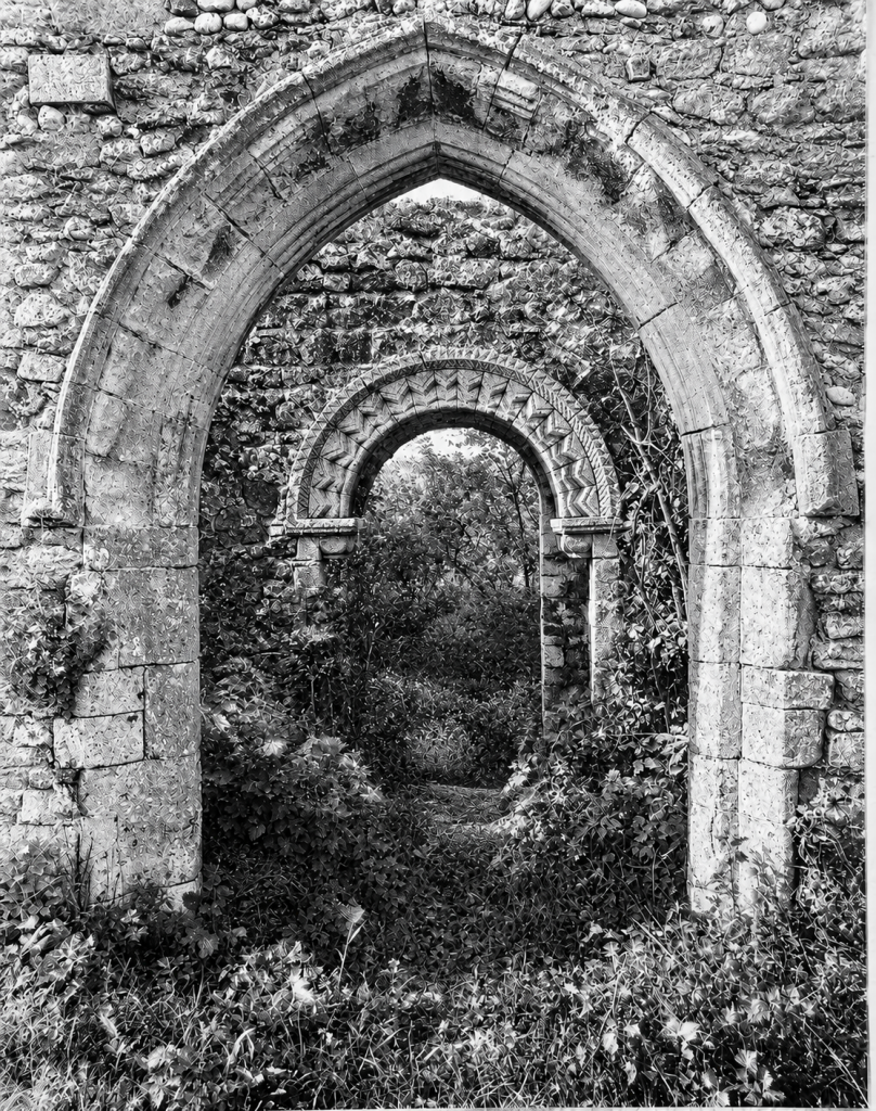 Mintlyn , St Michael, south doorway and south porch looking north, c.1935. A pile of rubble is all that remains today. 
B37/609 copyright Royal Commission on Historical Monuments (England).