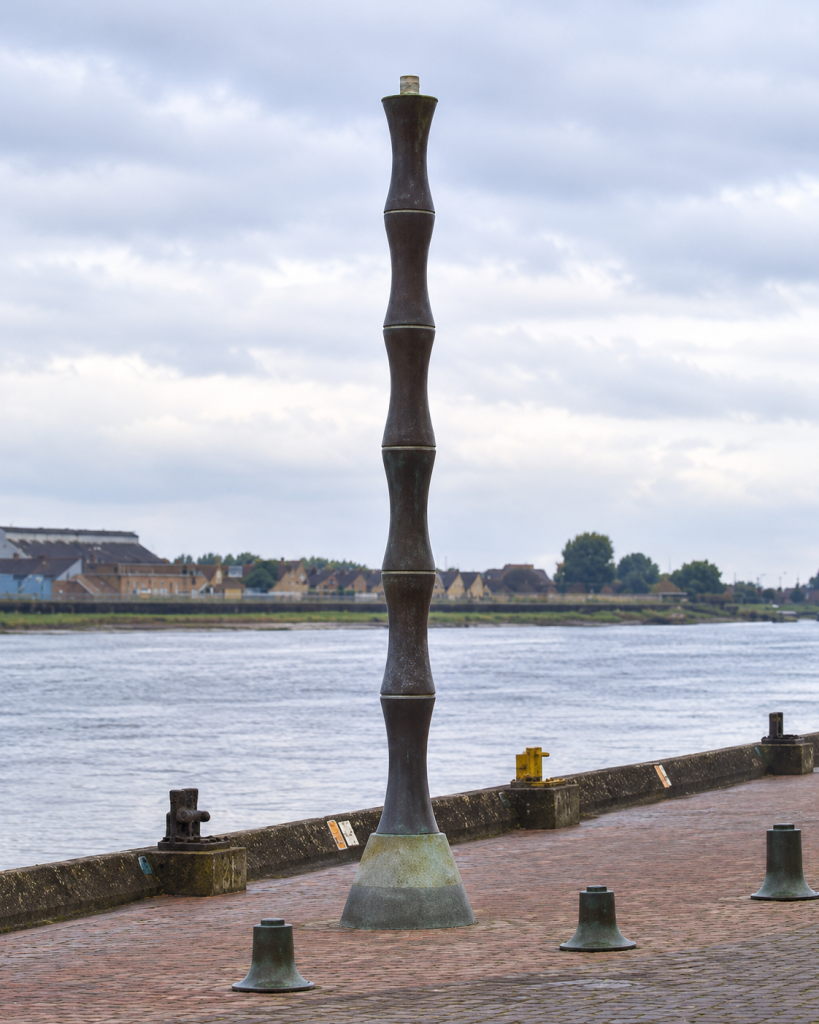 Andrew Schumann’s Half Fathom Column, installed during the improvement of South Quay around 2000. Half Fathom Column. According to the plaque it "ripples like the river water, flashes at night like the Wash buoys, and climbs as high as the tidal rise". 
Source: Stephen Craven