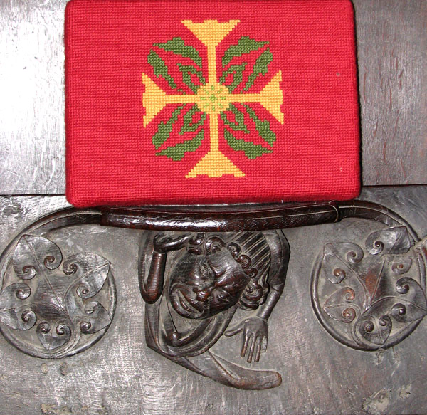 A fourteenth-century misericord. Its central figure is flanked by smaller foliate carvings. 
Photo © Evelyn Simak 2010