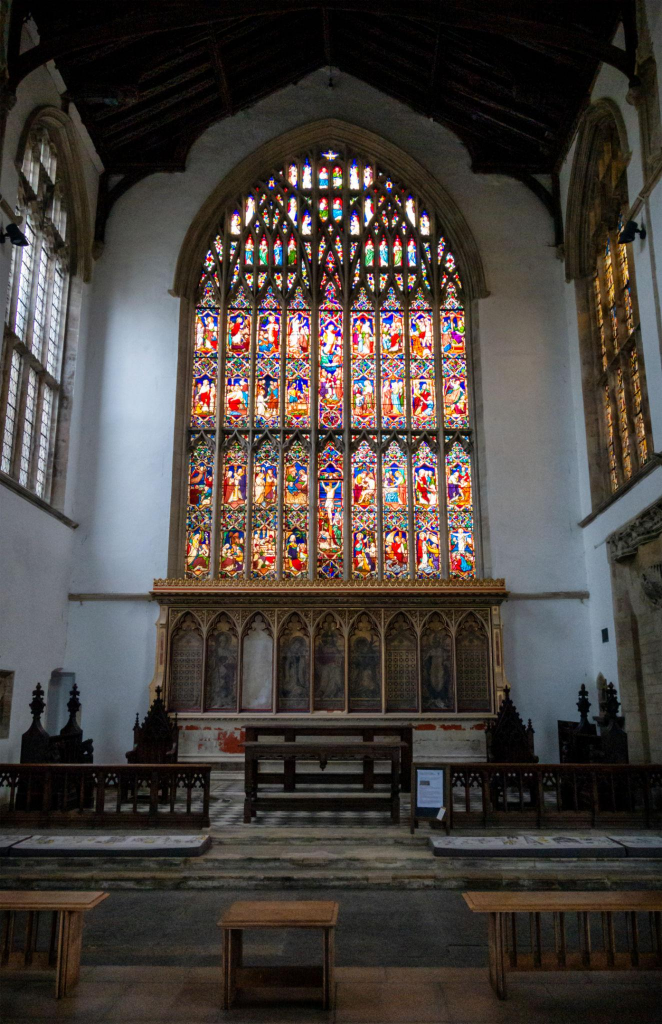 The Victorian east window and reredos at St Nicholas’ Chapel. The medieval glass is gone, and the present east end is the result of nineteenth and twentieth-century restoration. Source: Wikimedia Commons
