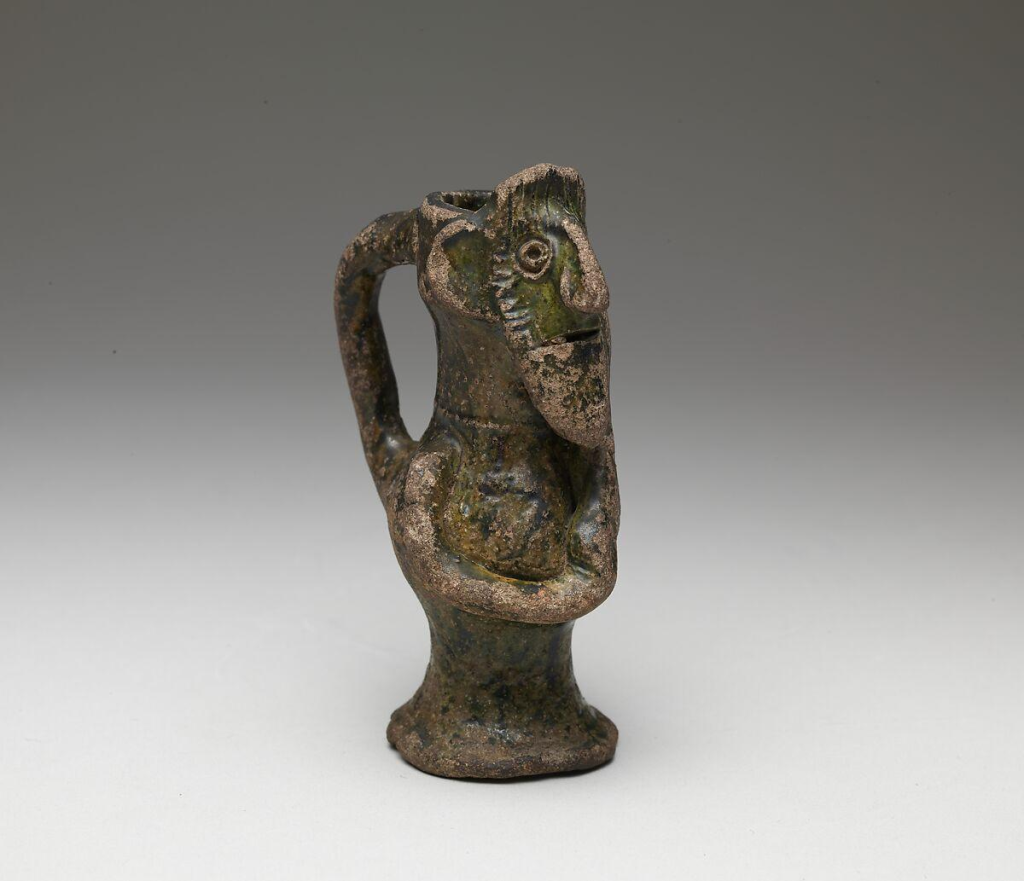 A remarkable Grimston-type face jug reconstructed from seventeen pottery fragments discovered in Suffolk. Its elaborate decoration includes human faces with pointed beards and arms extending across the vessel.
Photograph: CC BY SA 2.0, the Portable Antiquities Scheme/The Trustees of the British Museum. 